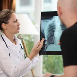 Lege viser pasient et røntgenbilde