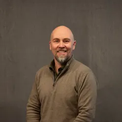 Mann med skjegg som smiler mot kamera