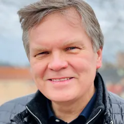 En mann som smiler til kameraet