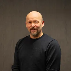 Mann med skjegg og bart poserer for et portrett mens han ser inn i kamera