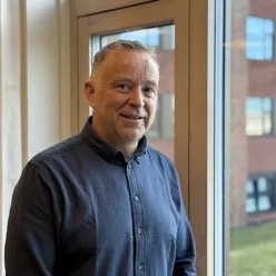 En mann som står foran et vindu