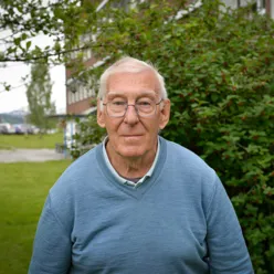 Mann med briller som ser inn i kameraet