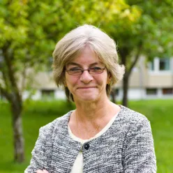 En smilende person med briller