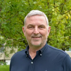 En mann som smiler til kameraet