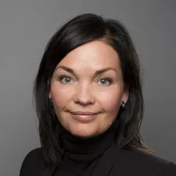 Dame med svart hår ser inn i kameraet