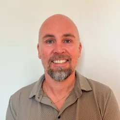 En mann som smiler til kameraet