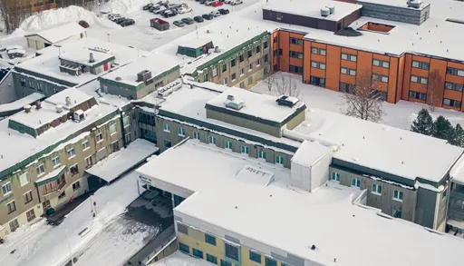 A building with a parking lot and snow on the ground