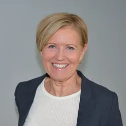 En kvinne som smiler til kameraet