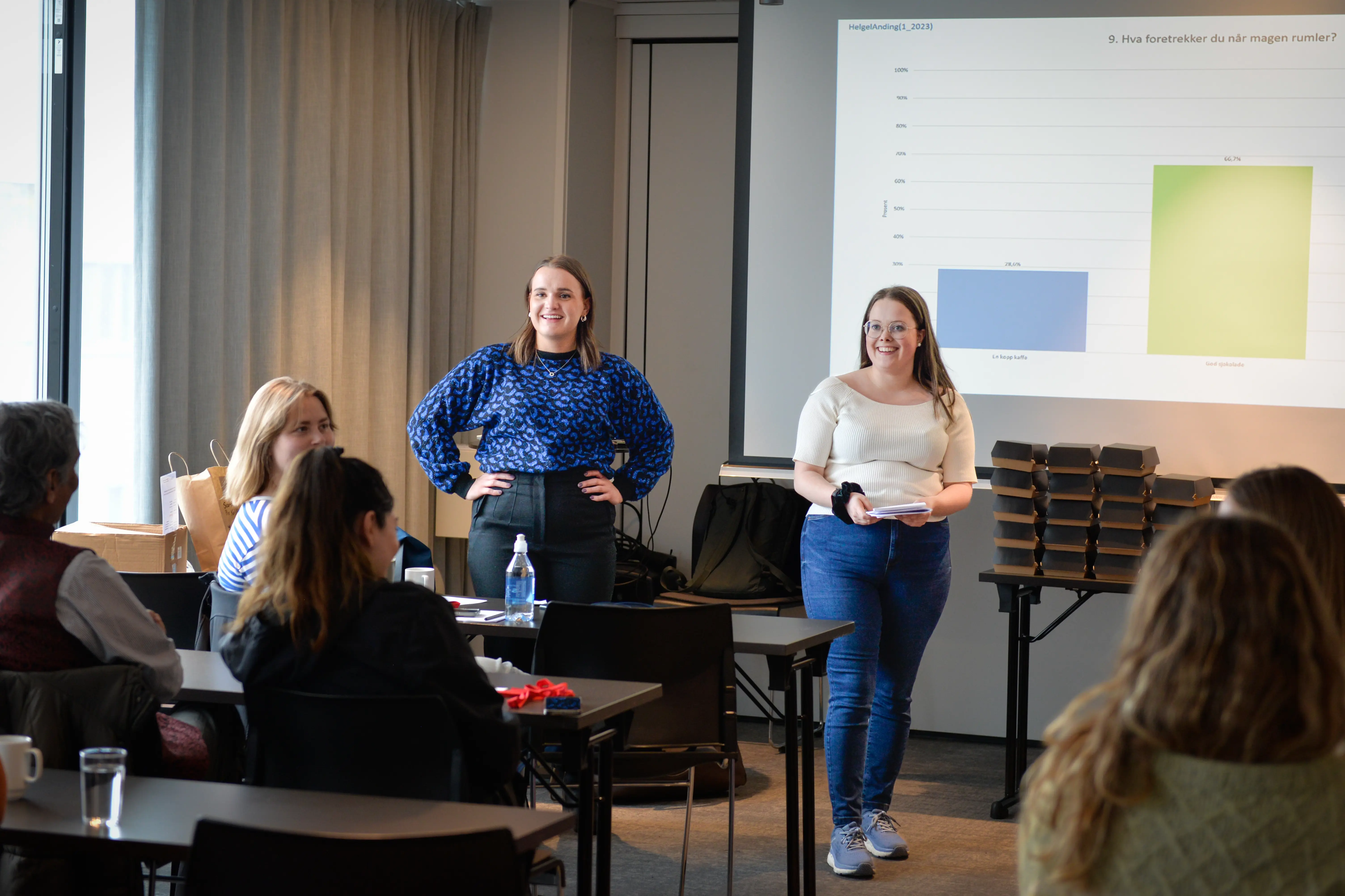 To damer står foran ei forsamling